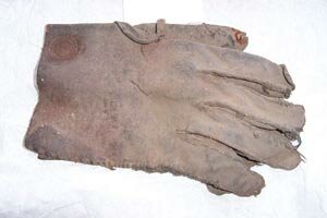 Image of a late 19th /early 20th century single leather glove found concealed under floorboards in a cottage in Cupar, Fife during electrical renovations. It is stamped with the maker's mark 'A. Honeyman, Saddler, Cupar, Fife'. A hat was also found with the glove. The glove remains with Fife Council Museums East and the hat has been donated to the Karen Finch Reference Collection at the Textile Conservation Centre.  Copyright Fife Council Museums East        